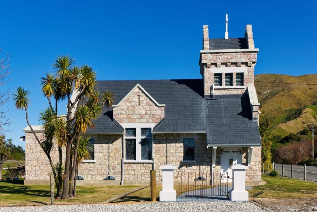 Historic stone church with tower and palm trees, perfect heritage wedding venue and ceremony chapel location
