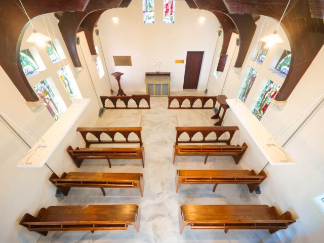 St Oswald Church Aerial view of Saint Oswald's Memorial Church interior showing wooden pews, stained glass windows, and altar—an elegant heritage wedding venue for intimate ceremonies.