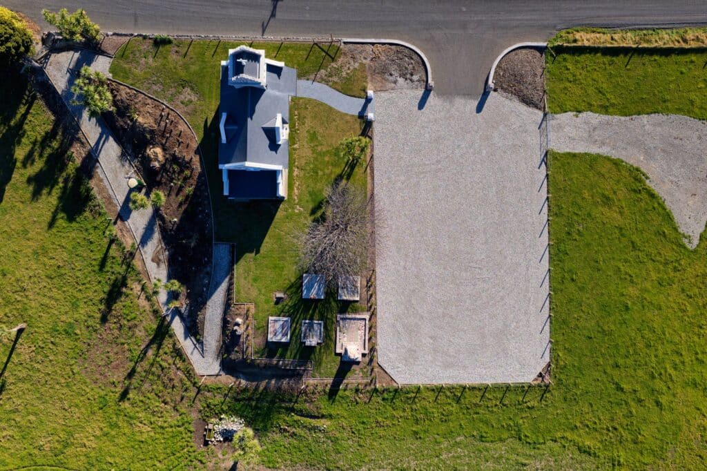 Aerial view of historic Saint Oswald's Memorial Church wedding venue surrounded by lush green grounds and gravel pathways, perfect for heritage ceremonies.