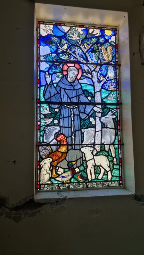 Beautiful stained glass window depicting Saint Francis with animals in historic Saint Oswald's Memorial Church, perfect for heritage wedding ceremonies