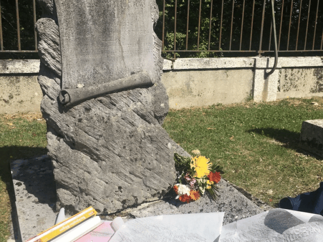 Historic stone memorial at Saint Oswald's heritage chapel with fresh flowers and ceremony programs, sacred wedding venue setting