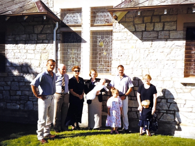 Family group at historic stone chapel courtyard with white-painted walls, ideal for intimate heritage wedding venue ceremonies and celebrations