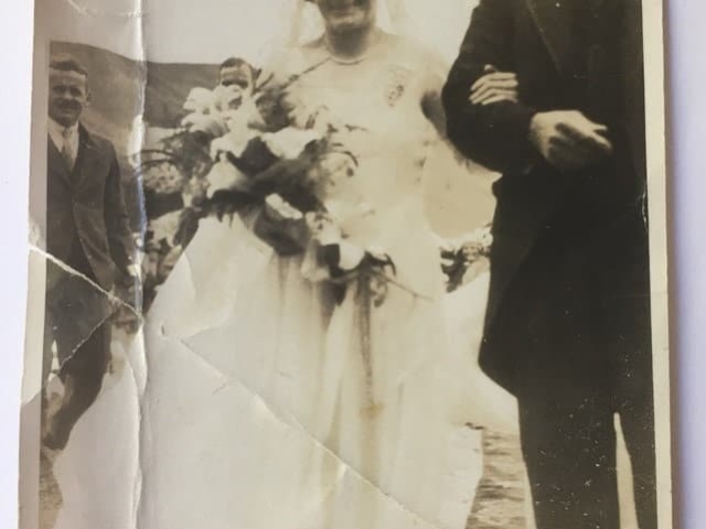 Vintage wedding photograph at heritage church showing bride in white dress with bouquet beside groom in formal suit during chapel ceremony